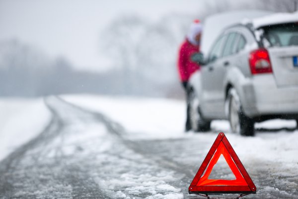 assurant vehicle service contracts extended car warranty car breakdown in winter car at the side of the road snow on the road red triangle in the foreground